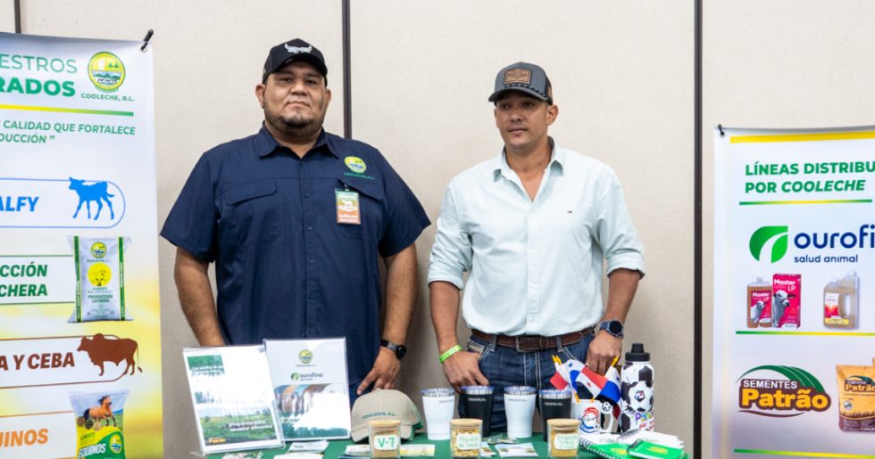 Dos representantes en el stand de COOLECHE, R.L. exhibiendo concentrados, insumos agropecuarios y mercancía promocional durante el Encuentro de Engordadores.